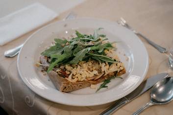 Teller mit Gemüse-Vollkorn-Pizza mit Ruccola und Kernen